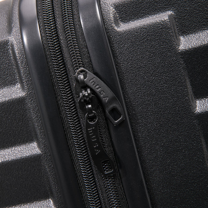 Close-up of a black zipper on a textured black surface