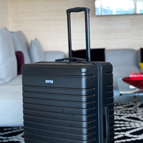 Black suitcase on a rug with a blurred indoor background