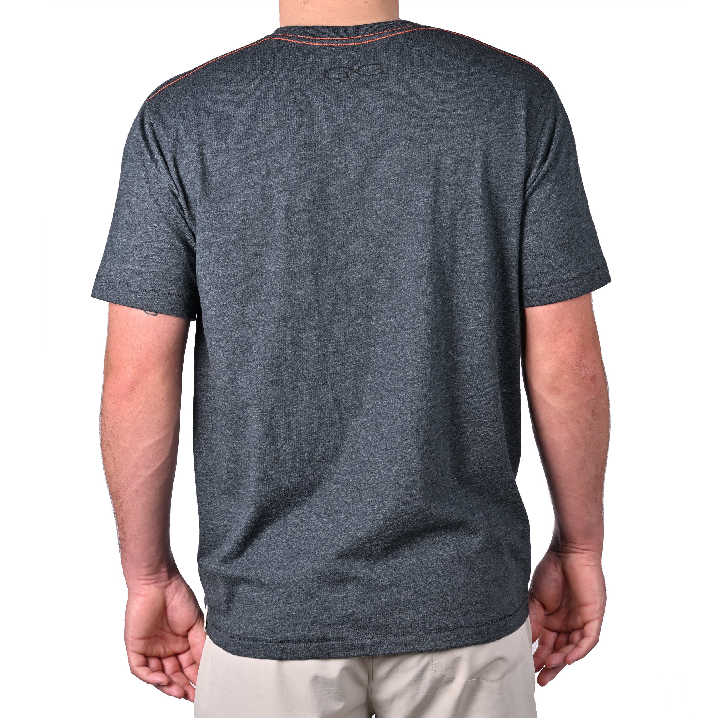 Person wearing a dark gray t-shirt with a brand logo on the back, standing against a white background