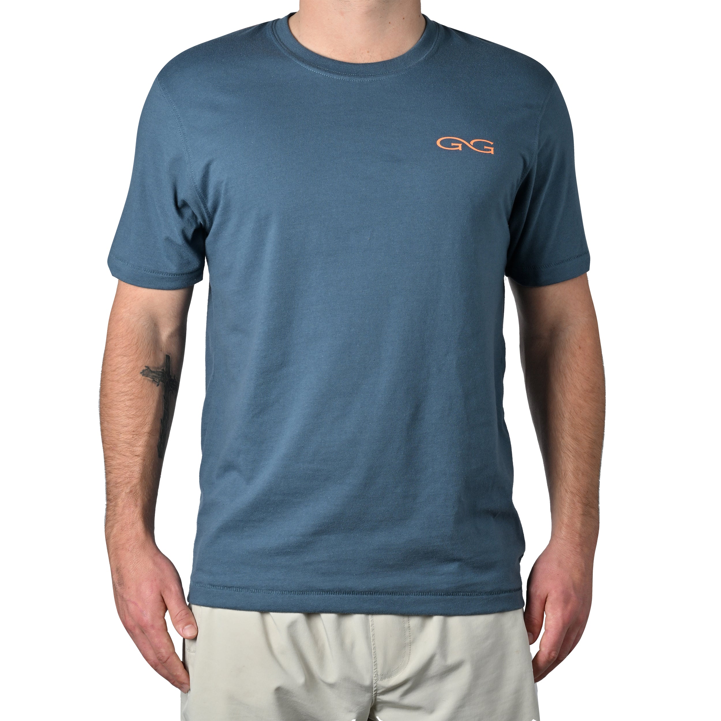 Person wearing a blue t-shirt with 'GG' logo on a white background