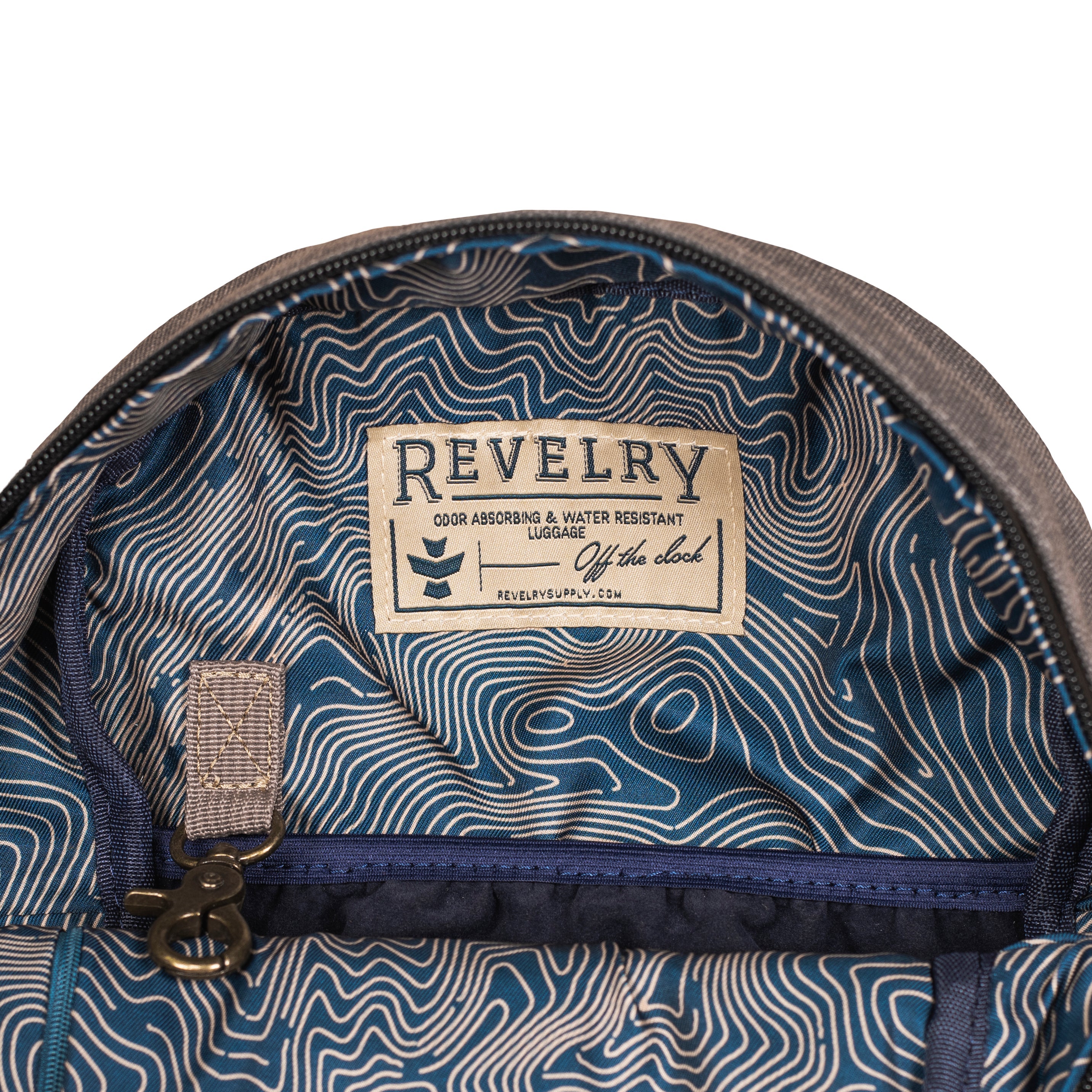 Close-up of a backpack interior with a 'Revelry' label on a white background