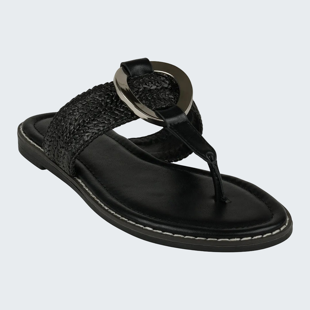 Black sandal with a circular metal buckle on a white background