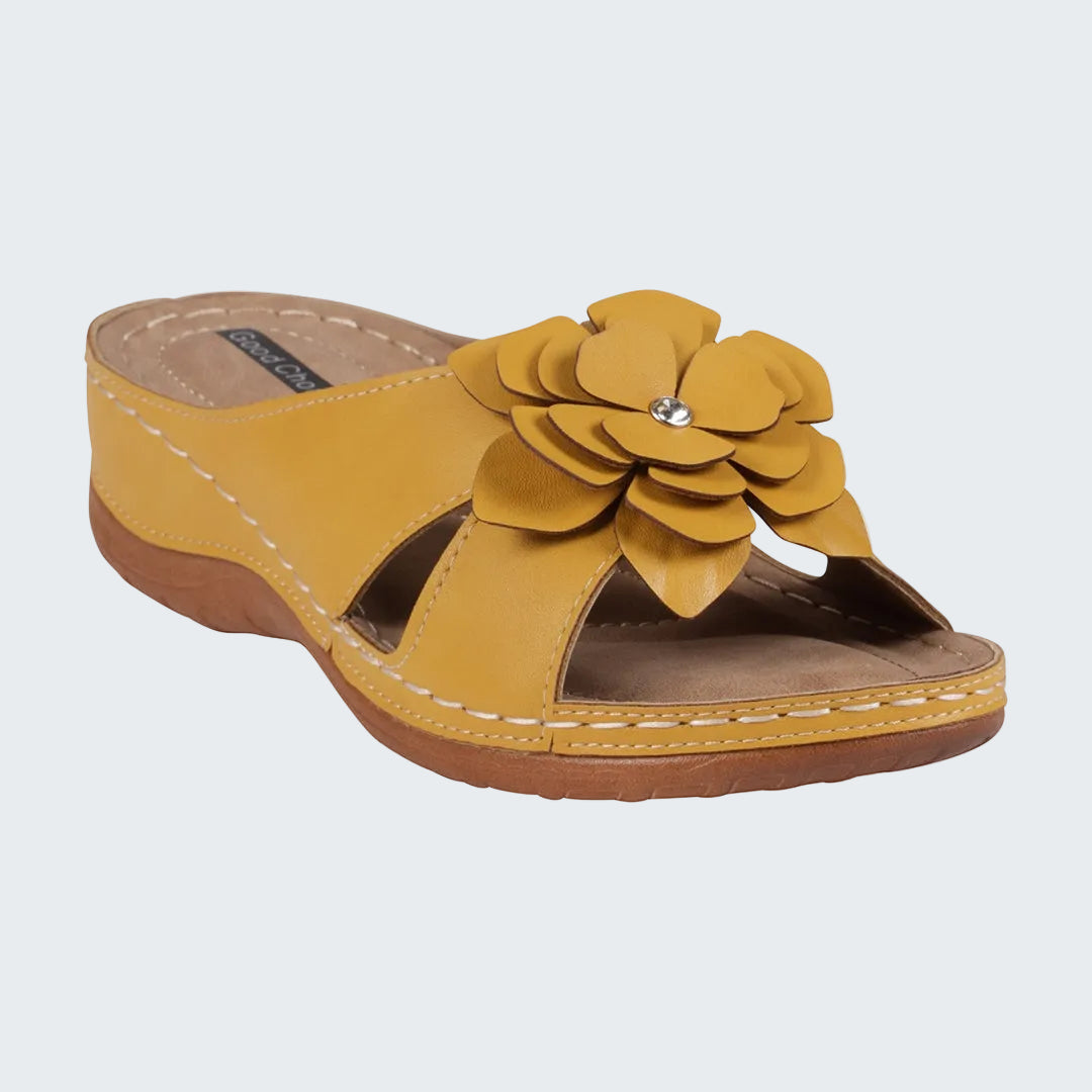 Yellow sandal with a flower design on a white background