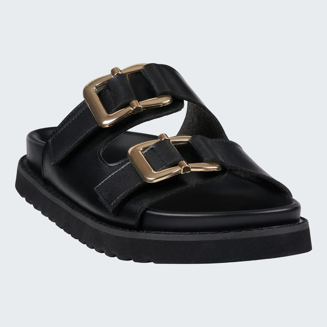 Black sandal with gold buckles on a white background