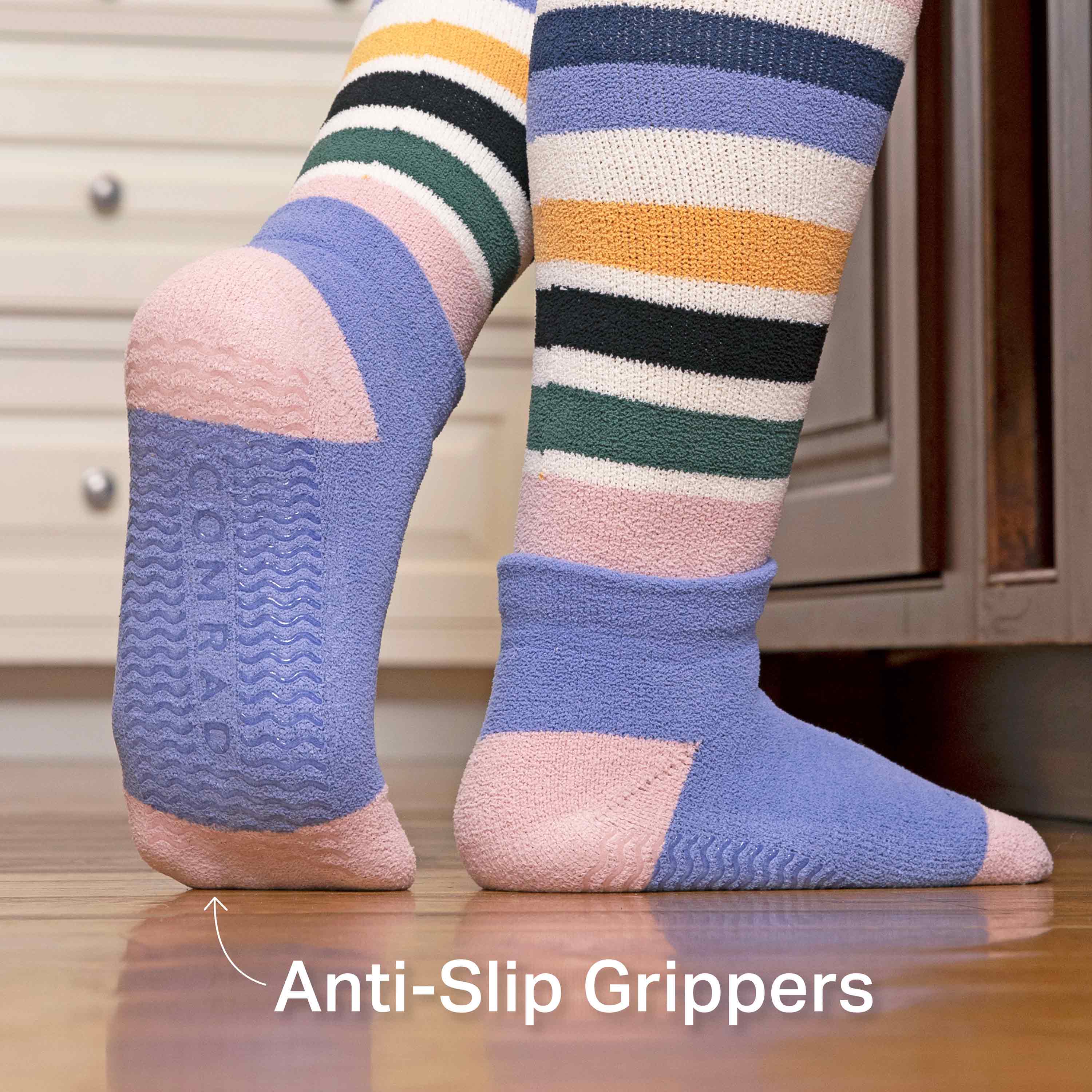 Colorful striped socks with anti-slip grippers on a wooden floor.