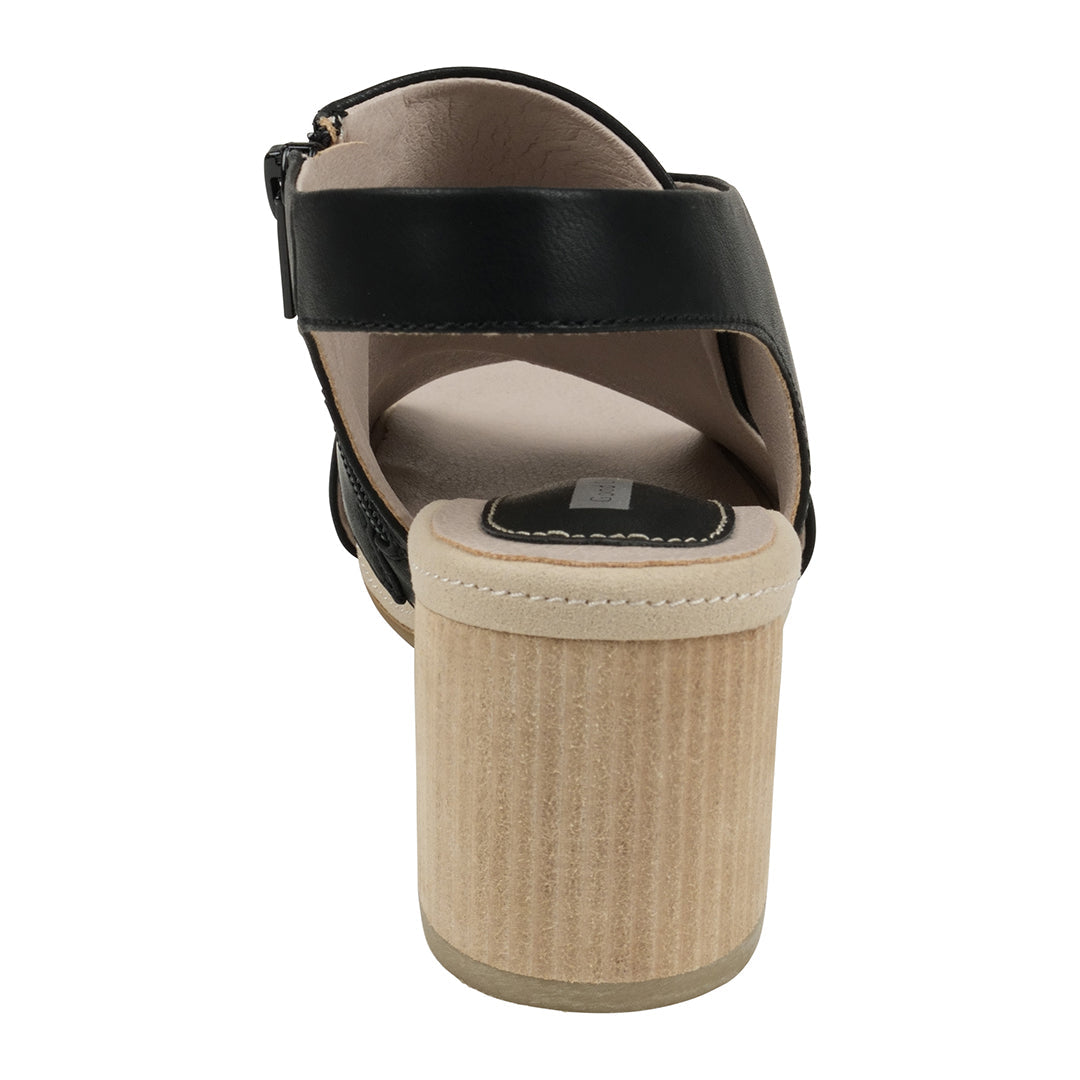 Black sandal with a beige wedge sole on a white background