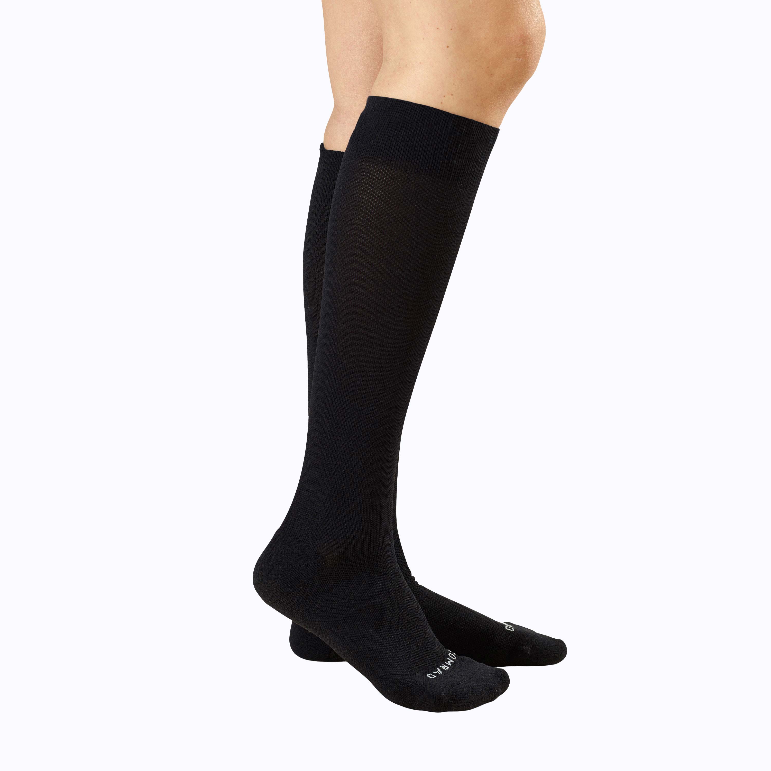 Black knee-high socks worn by a person on a white background