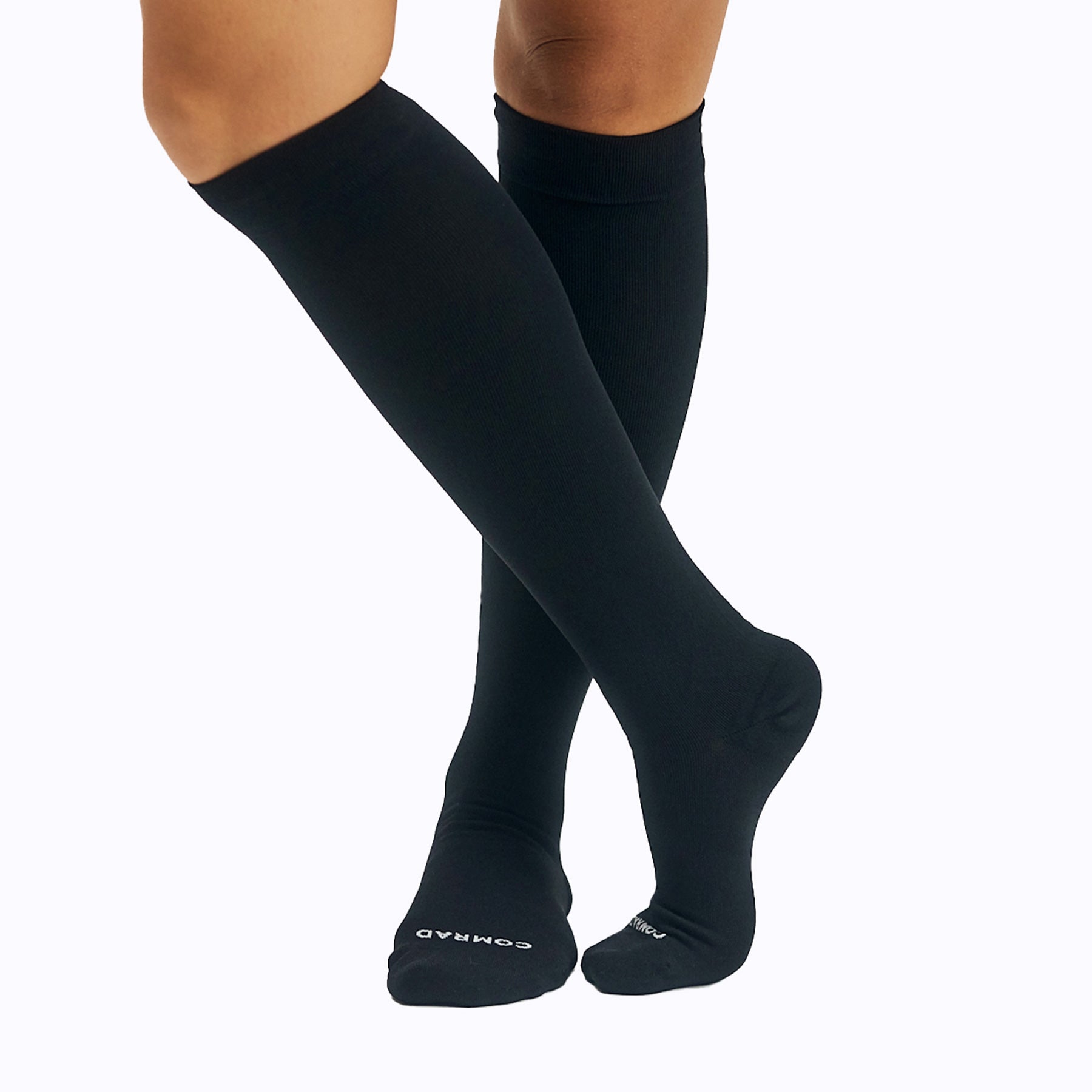 Black knee-high socks worn by a person on a white background