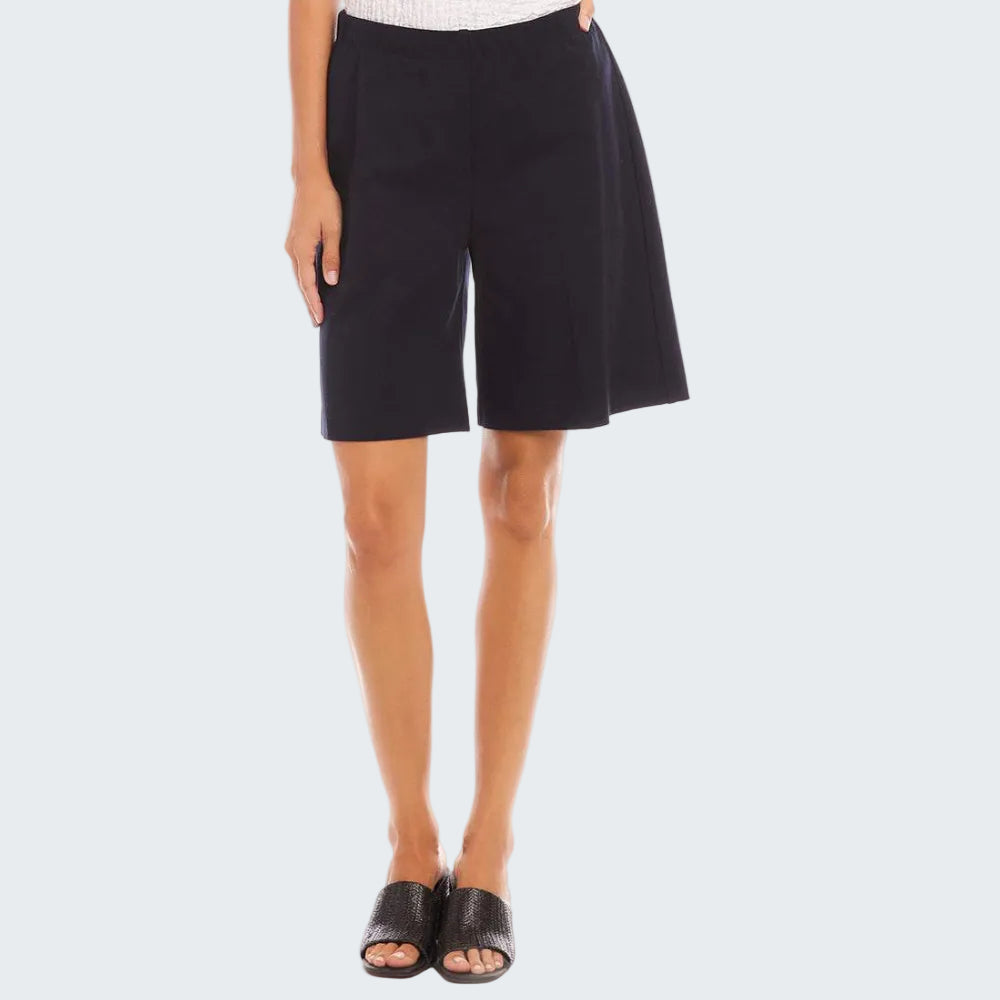 A model wearing black wide-leg shorts, a white textured top, and black slide sandals, shown from the waist down on a white studio background.