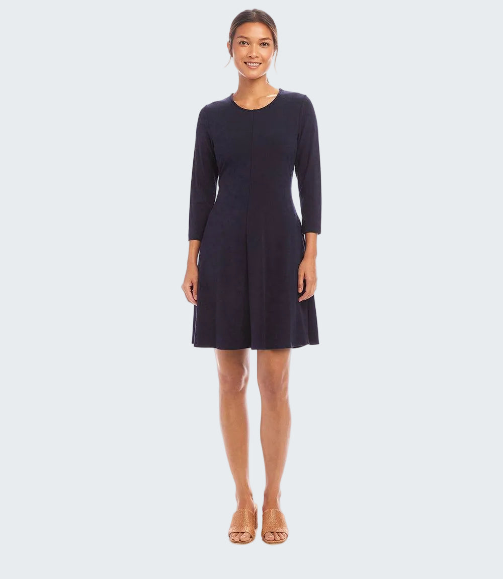 A woman modeling a dark navy blue knee-length dress with three-quarter sleeves and a round neckline, standing against a plain white studio background.