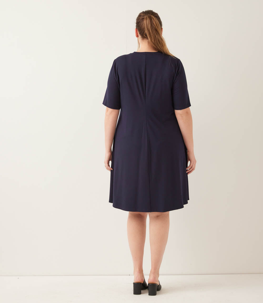 Woman wearing a navy blue dress against a white background