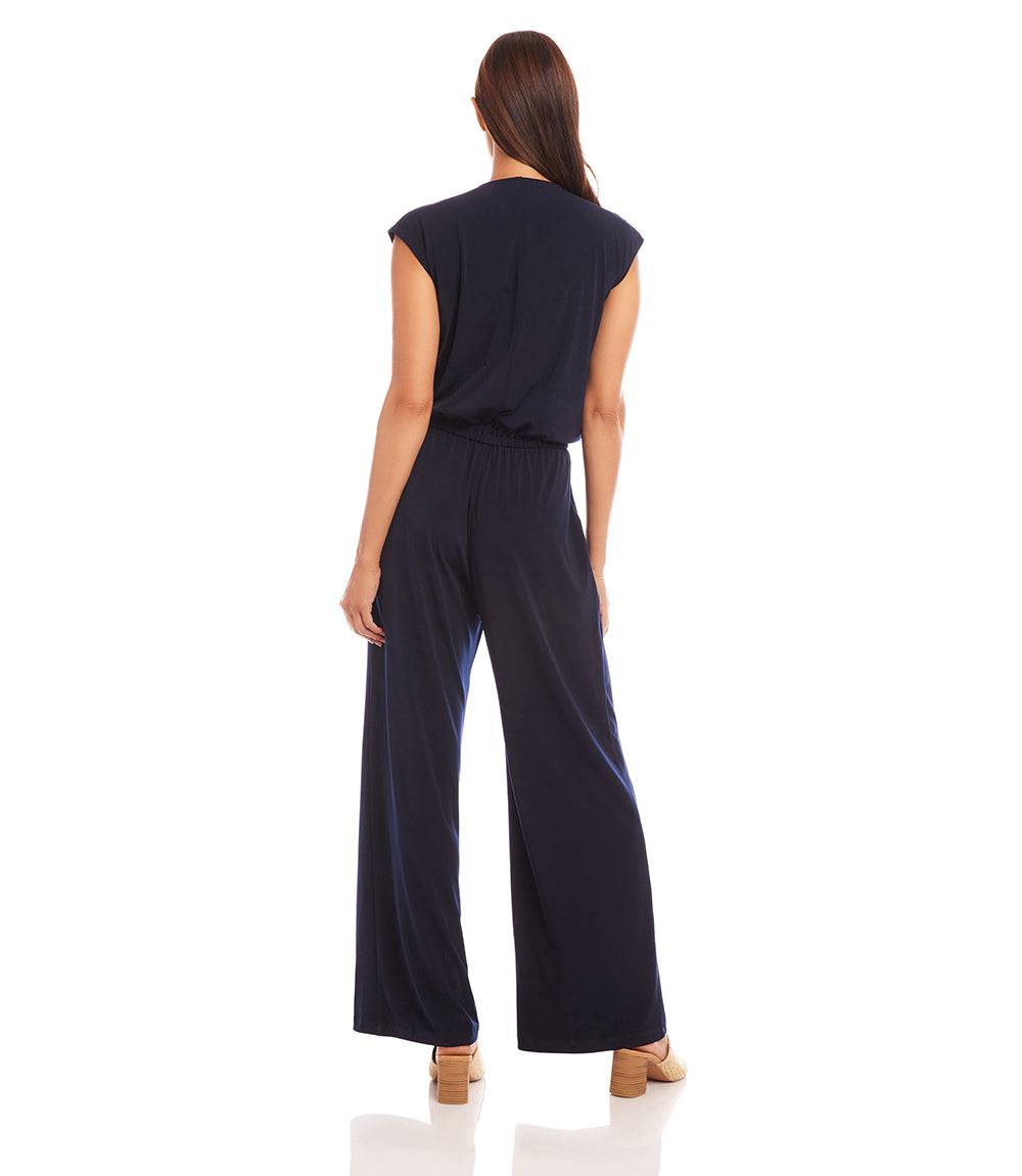 Woman wearing a navy blue jumpsuit on a white background