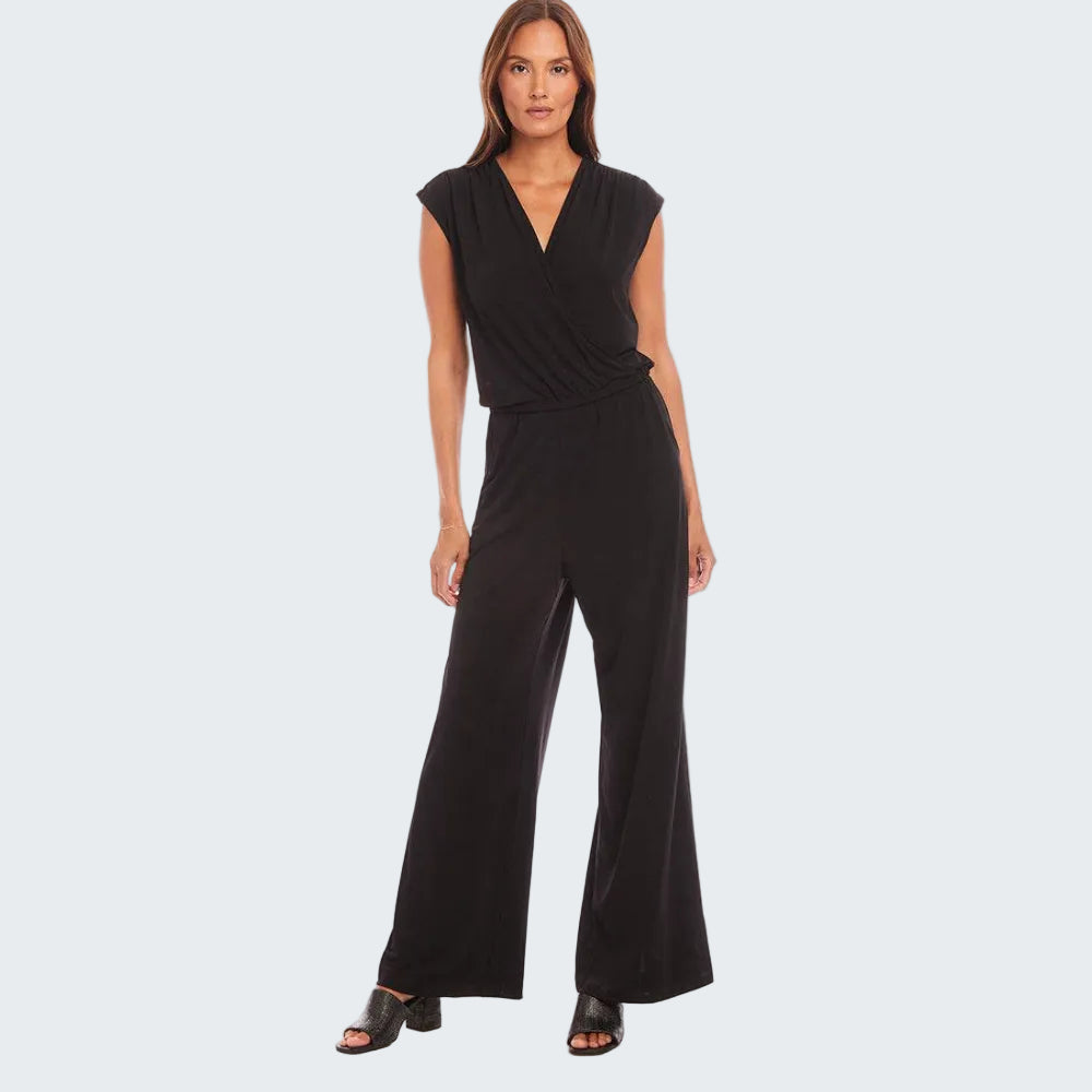 A woman modeling a black sleeveless wrap-style jumpsuit with wide legs, photographed against a plain white studio background.