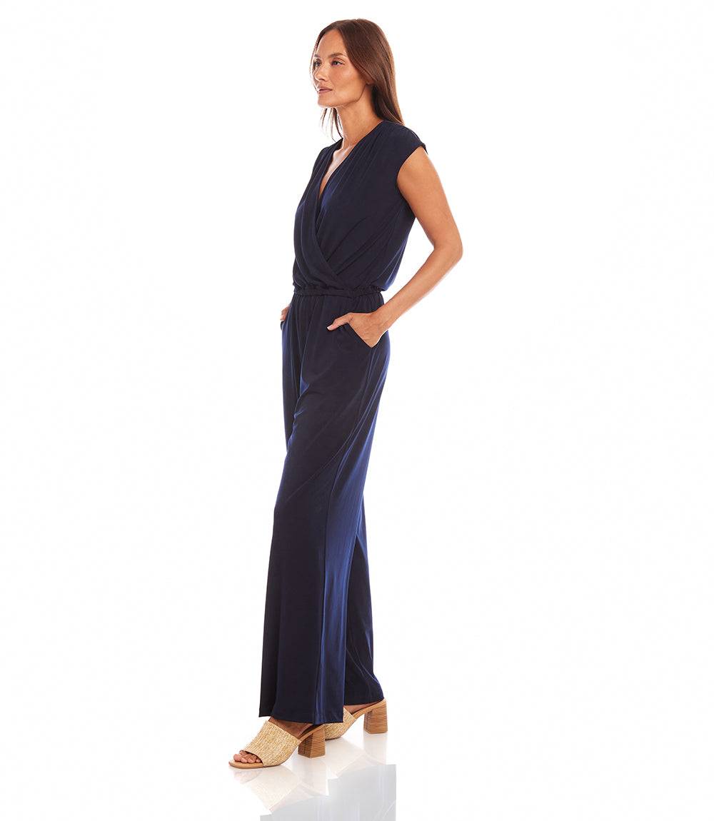 Woman wearing a navy blue jumpsuit on a white background