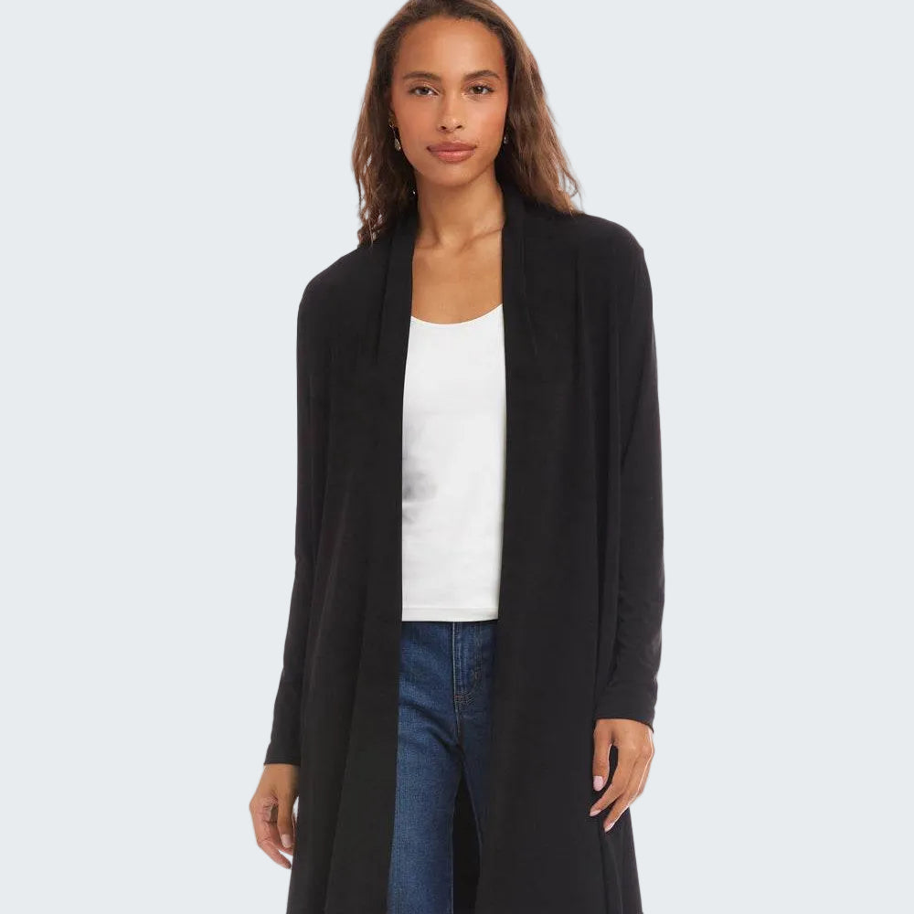 A woman modeling a black open-front longline cardigan over a white tank top and blue jeans, shot against a plain white studio background.
