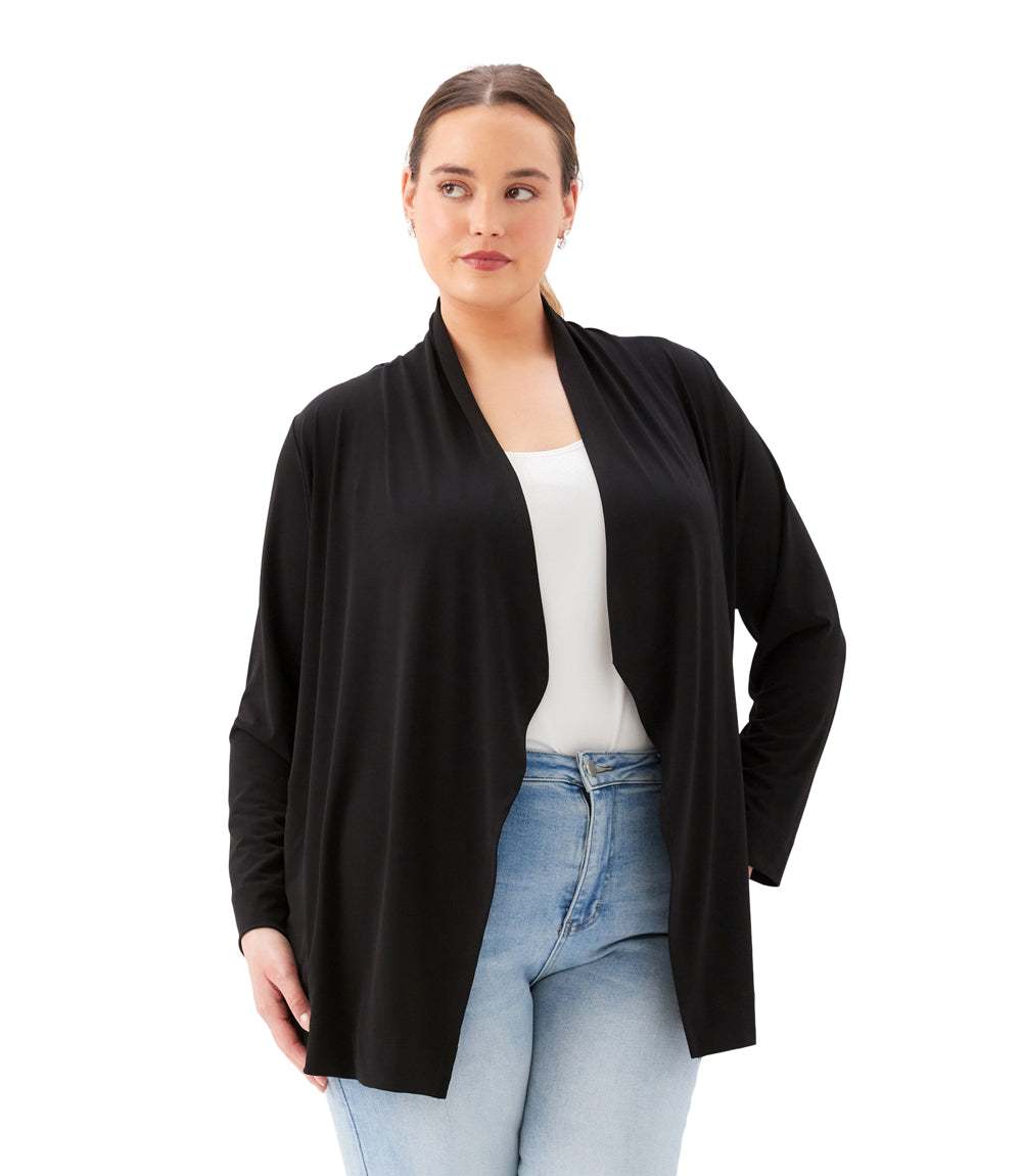 Woman wearing a black cardigan over a white top and blue jeans on a white background