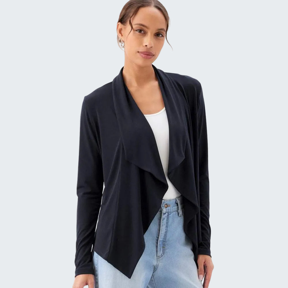 Woman wearing a black cardigan over a white top and light blue jeans on a white background