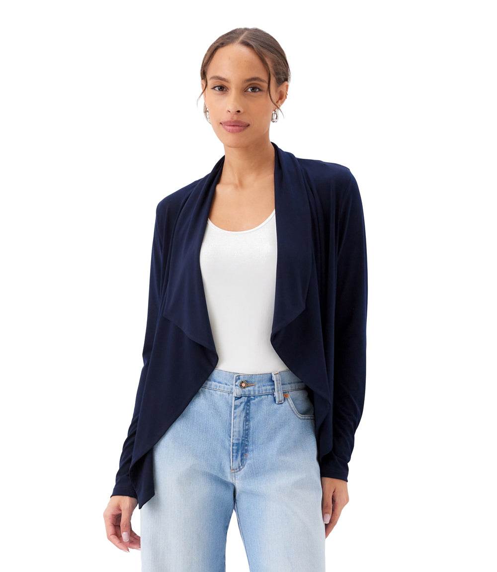 Woman wearing a navy cardigan over a white top and light blue jeans on a white background