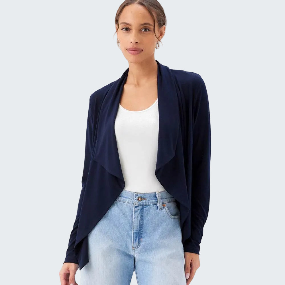 Woman wearing a navy cardigan over a white top and light blue jeans on a white background