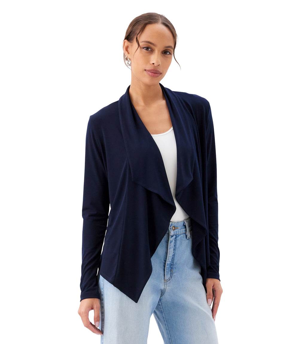 Woman wearing a navy blue cardigan over a white top and light blue jeans on a white background