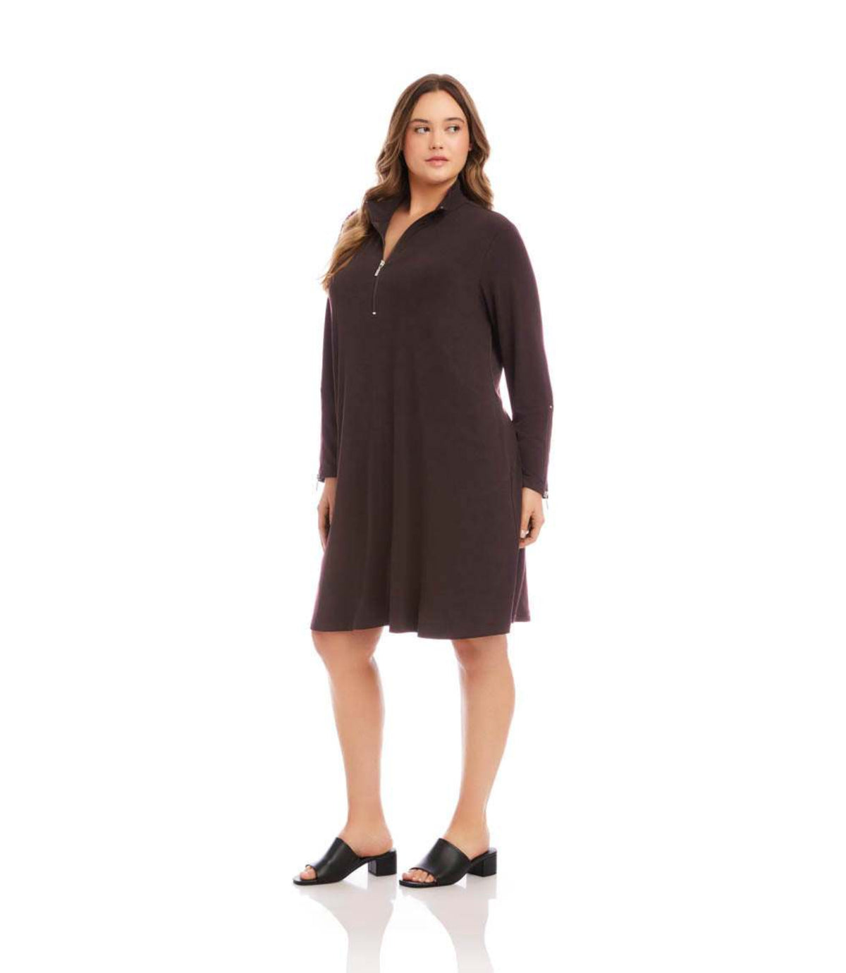 A woman modeling a dark brown long-sleeve knit shift dress with a buttoned collar, standing against a plain white studio background.