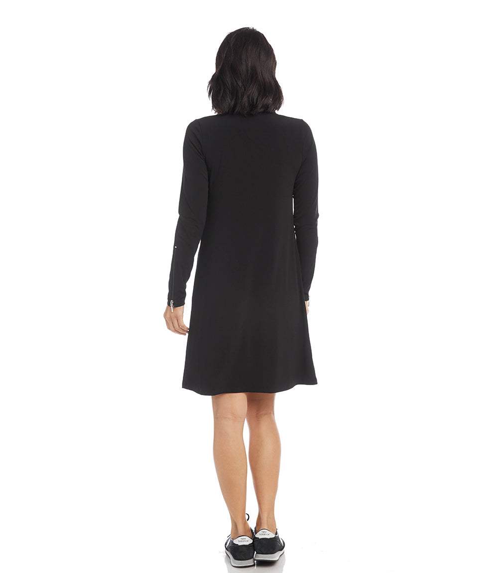A woman viewed from the back wearing a black long-sleeve shift dress, paired with black sneakers, against a plain white background.