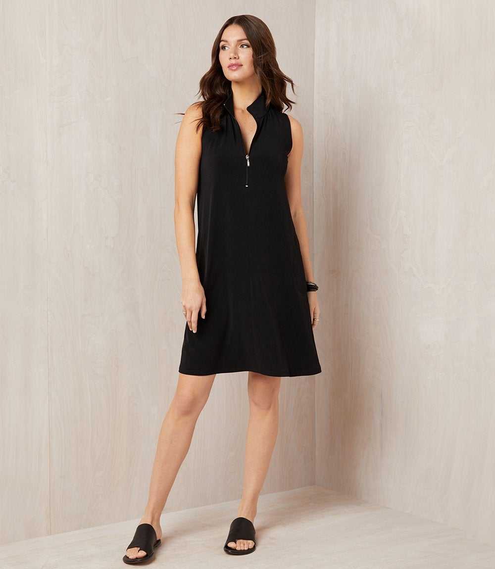 Woman wearing a black sleeveless dress against a neutral background