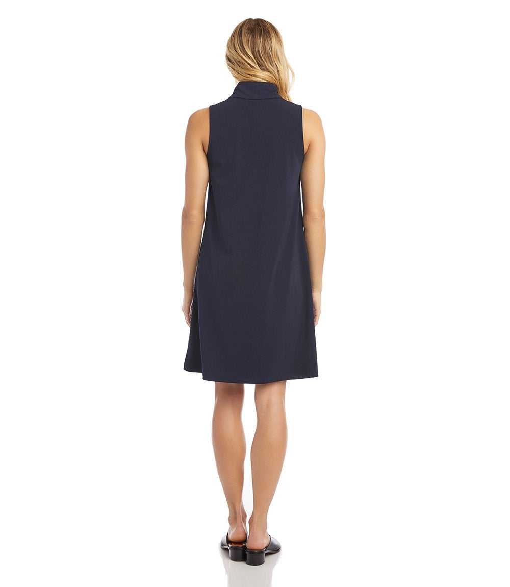 Woman wearing a sleeveless navy dress on a white background