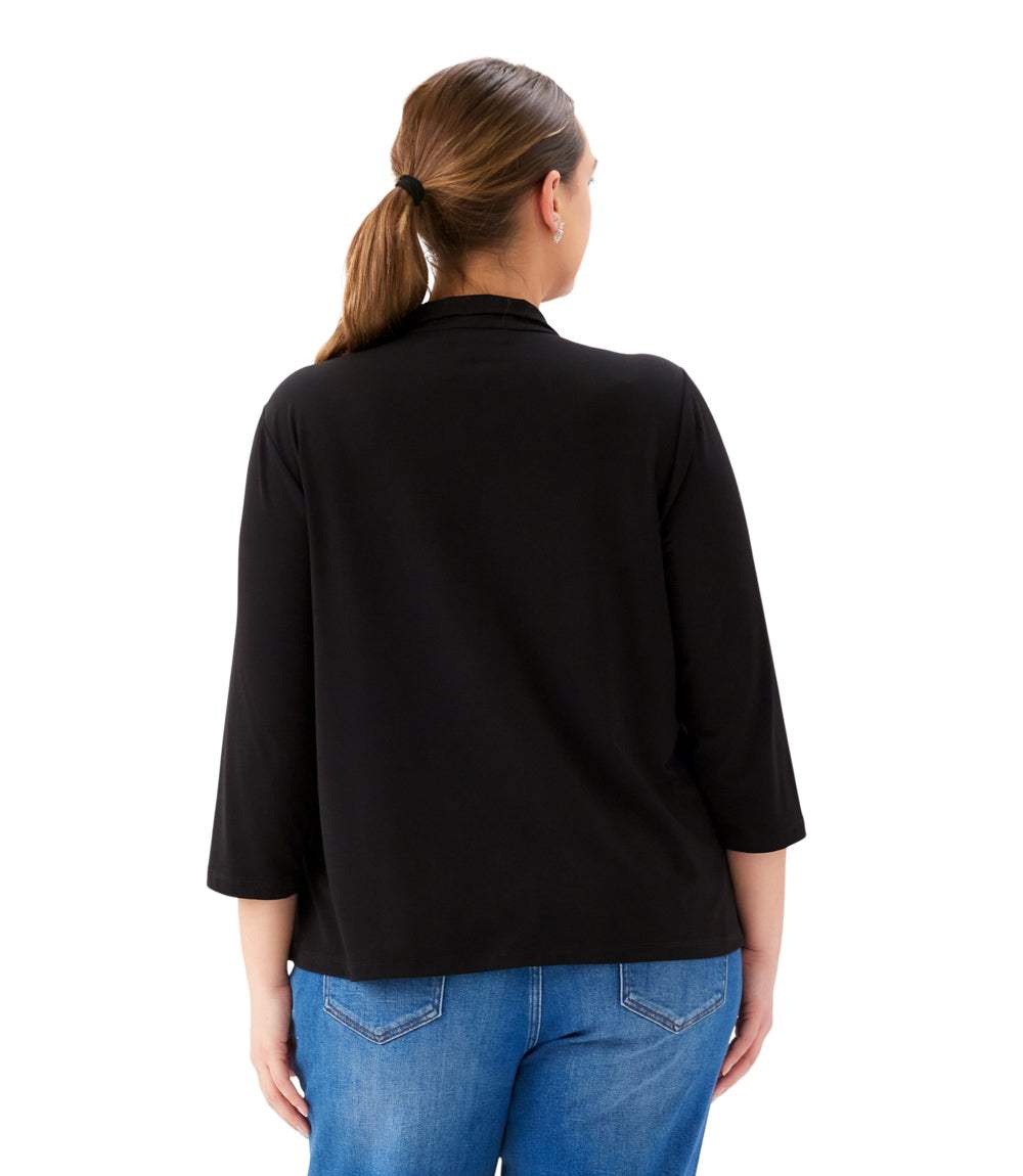Woman wearing a black top and blue jeans on a white background