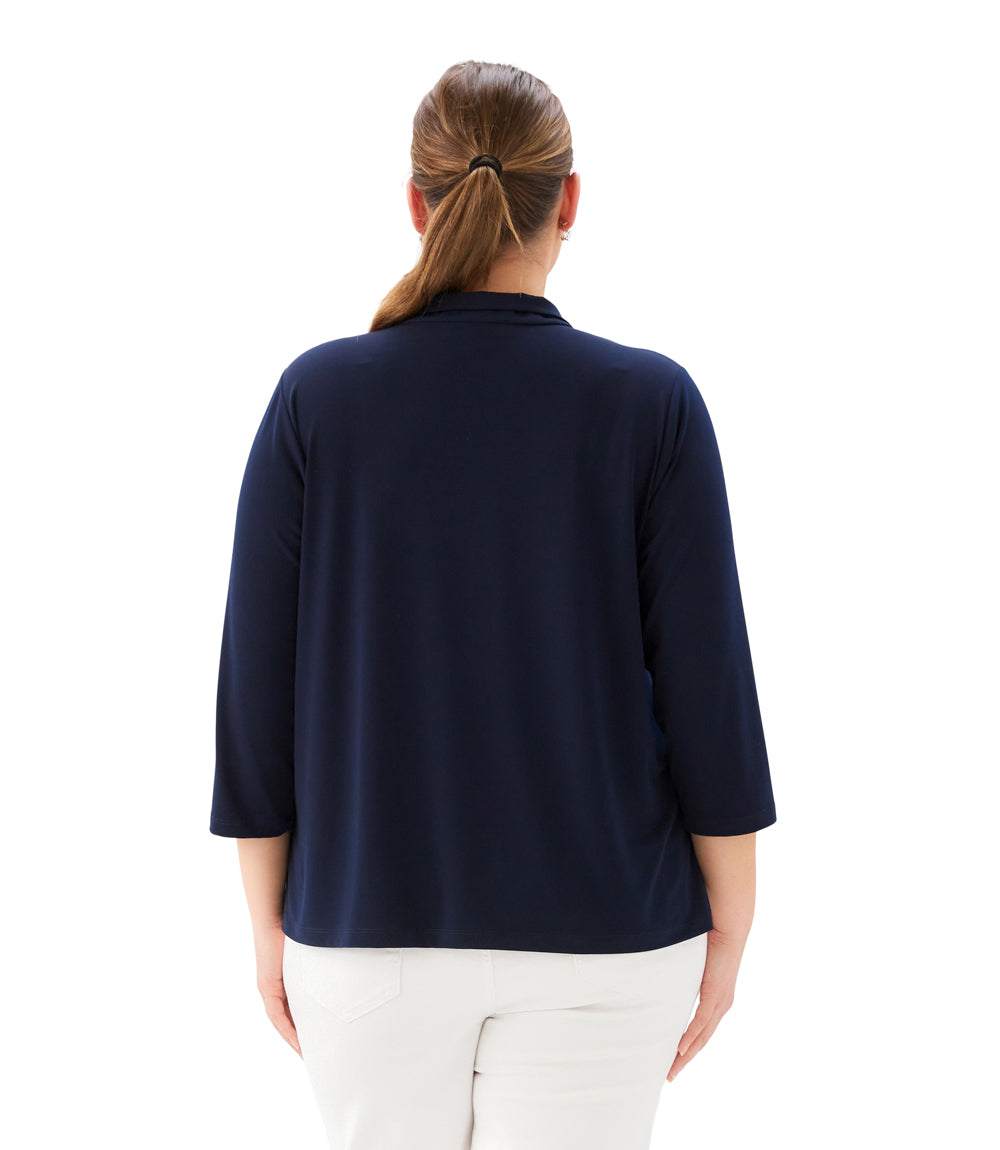 Woman wearing a navy blue top and white pants on a white background