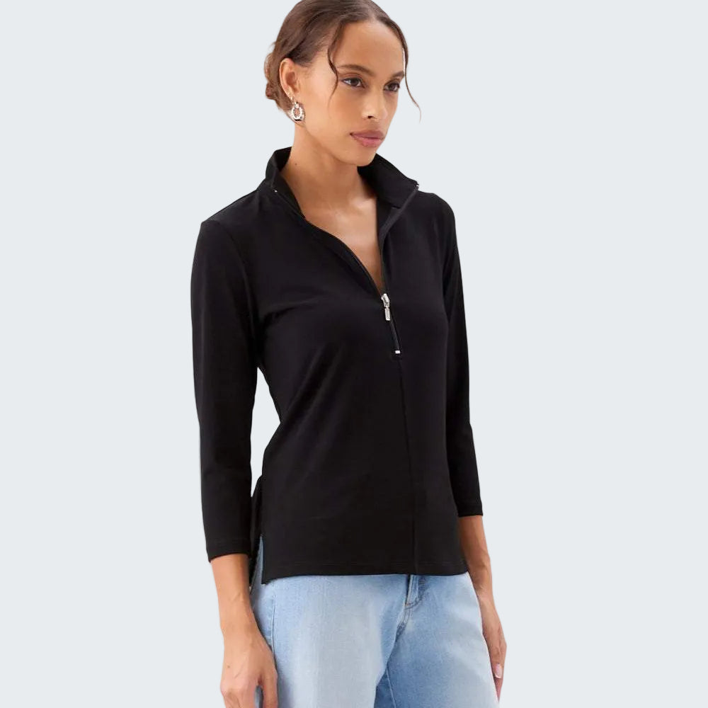 Woman wearing a black zip-up top and light blue jeans on a white background