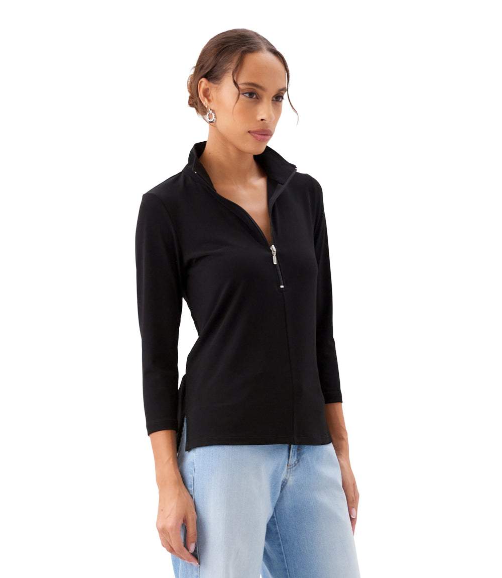 Woman wearing a black zip-up top and light blue jeans on a white background