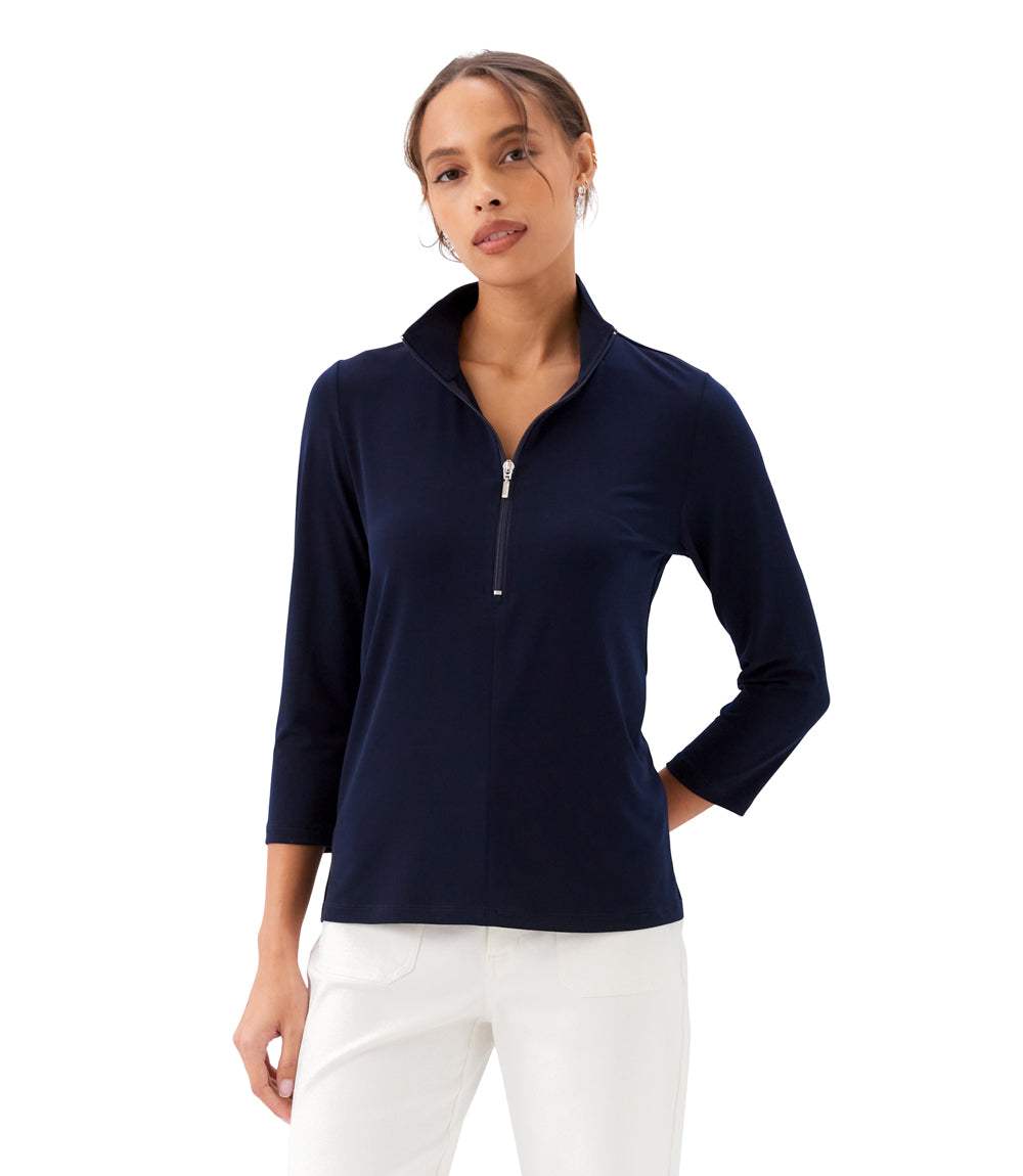 Woman wearing a navy blue long-sleeve top with a quarter zip on a white background
