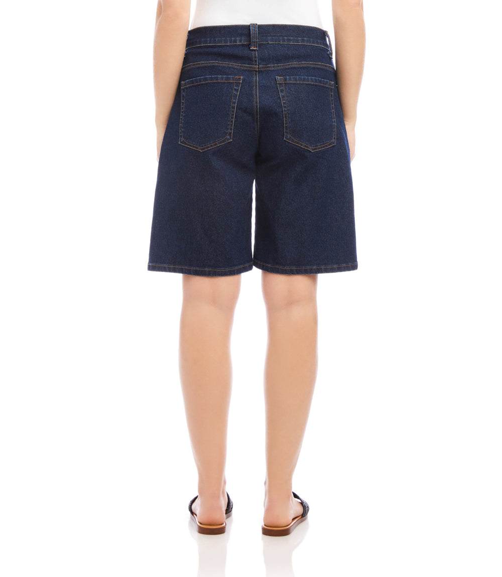 Person wearing dark blue denim shorts on a white background