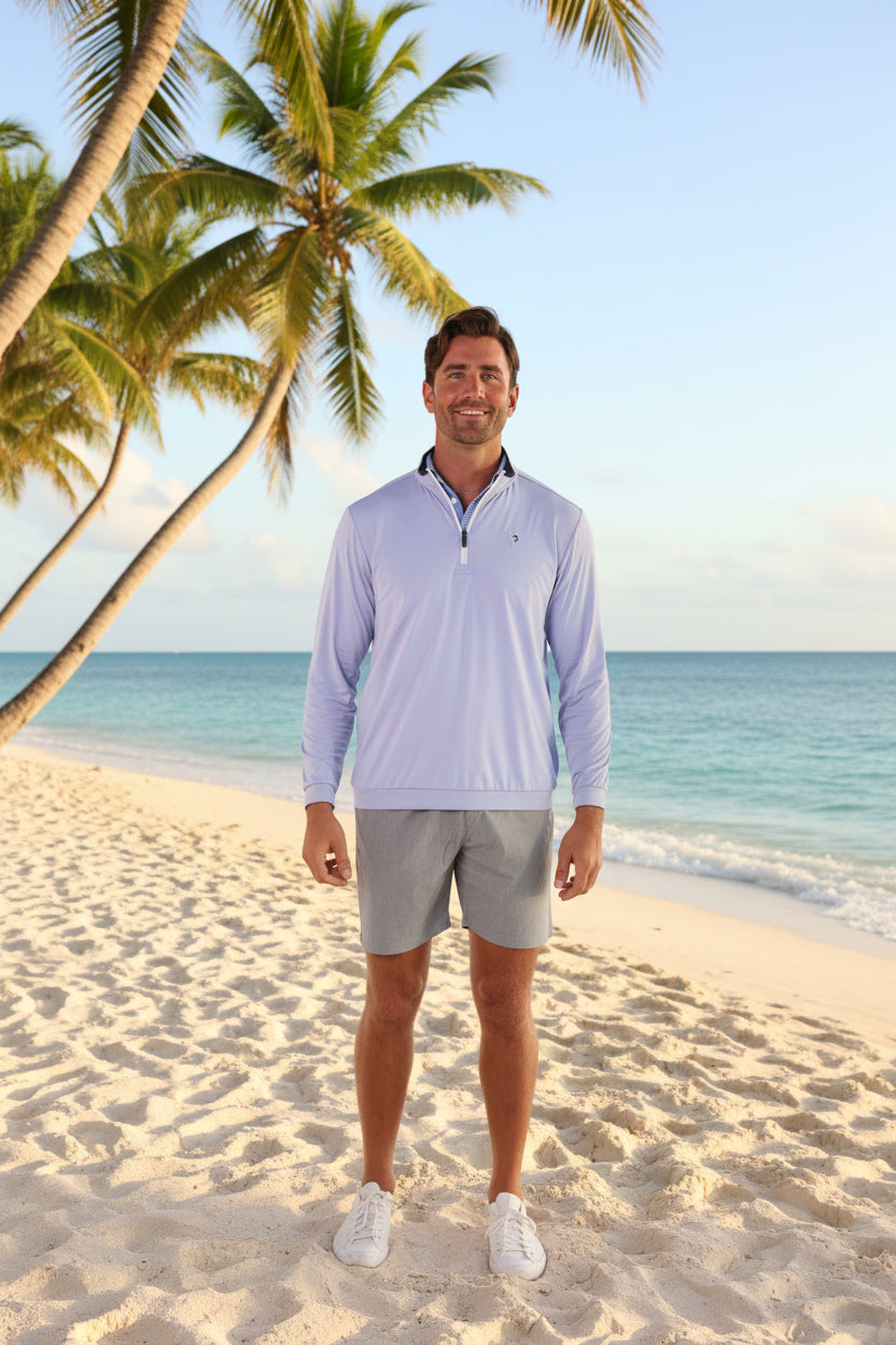 Man wearing a light purple long-sleeve shirt and gray shorts on a white background