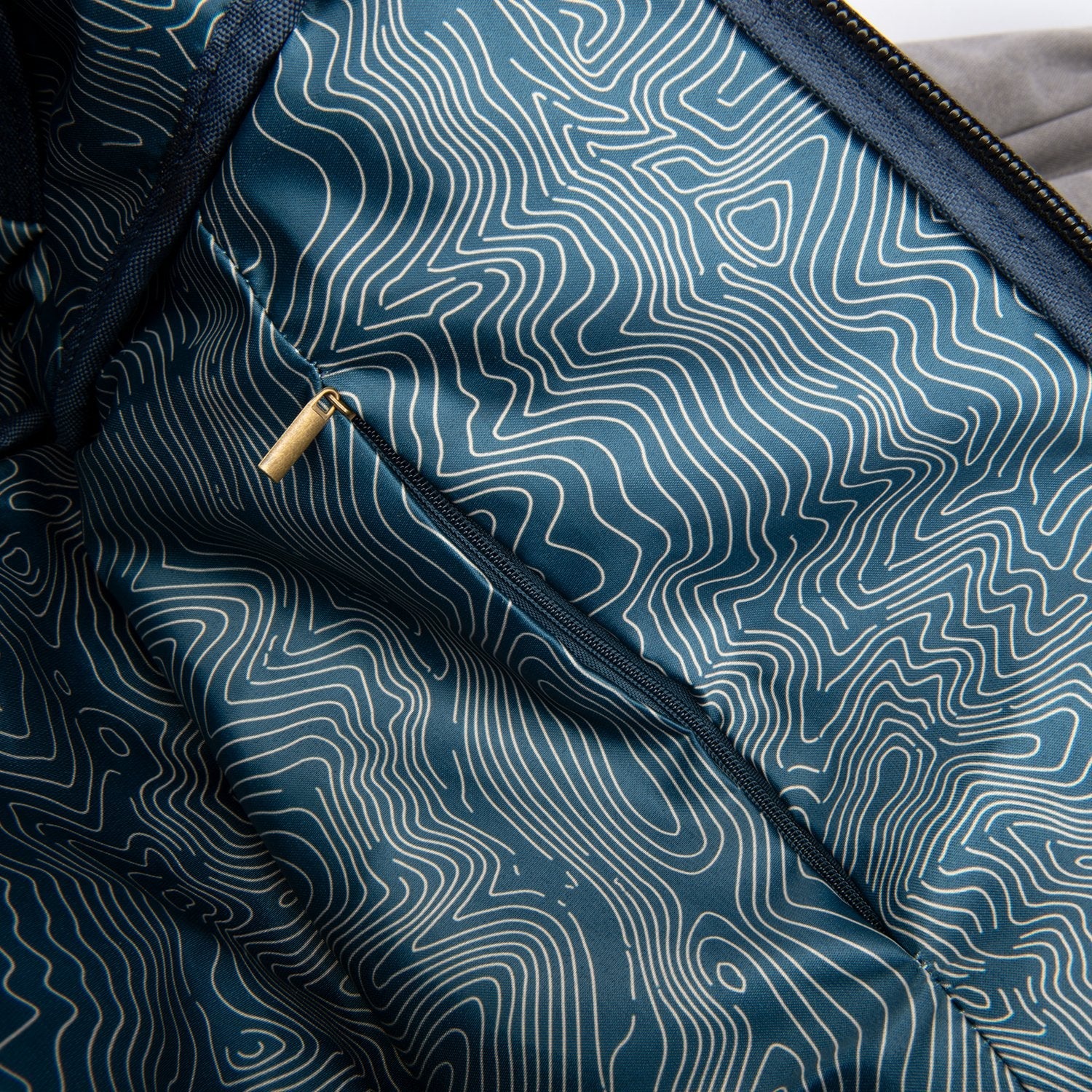 Close-up of a blue fabric with wavy white pattern and zipper