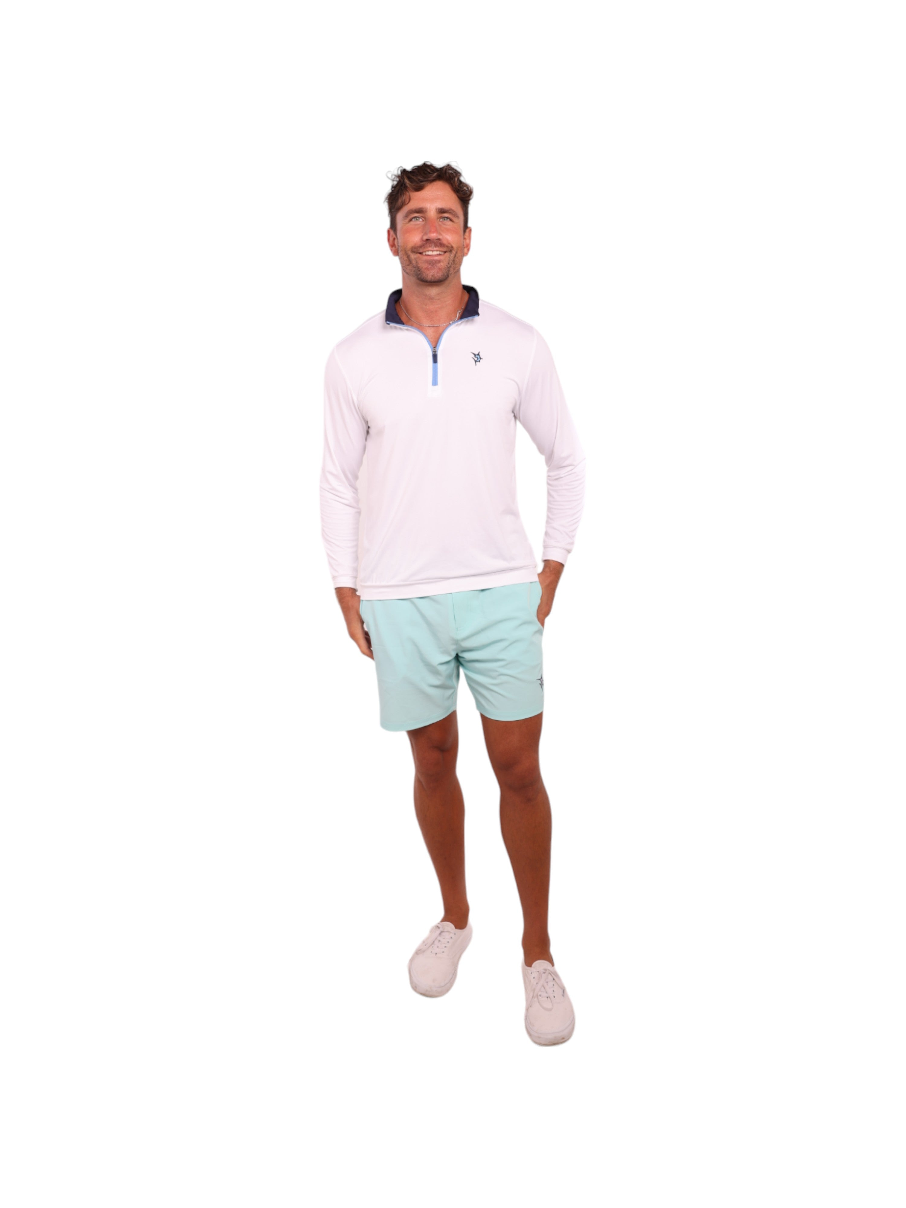 Man wearing a light pink long-sleeve shirt and light green shorts on a white background