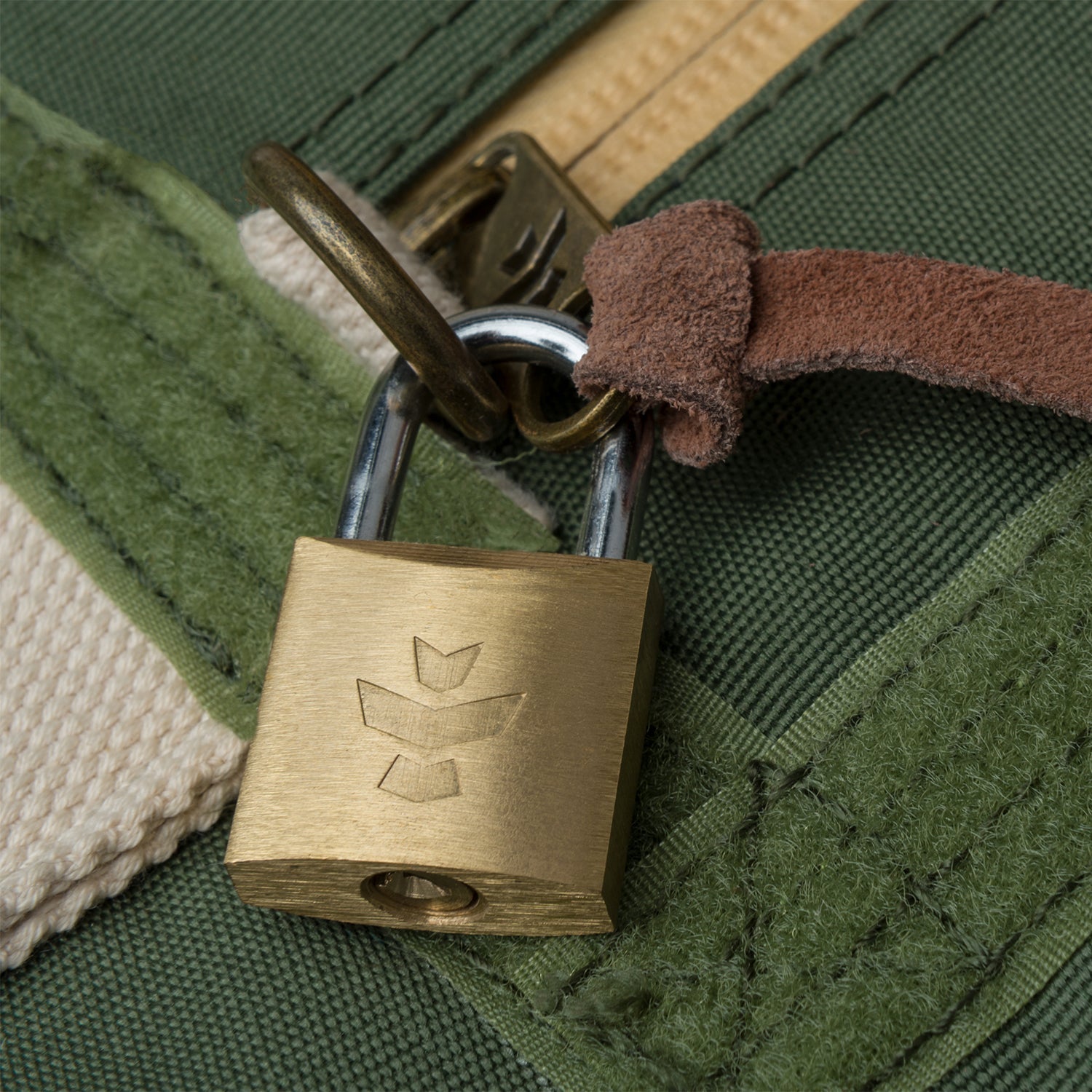 Brass padlock on a green fabric background