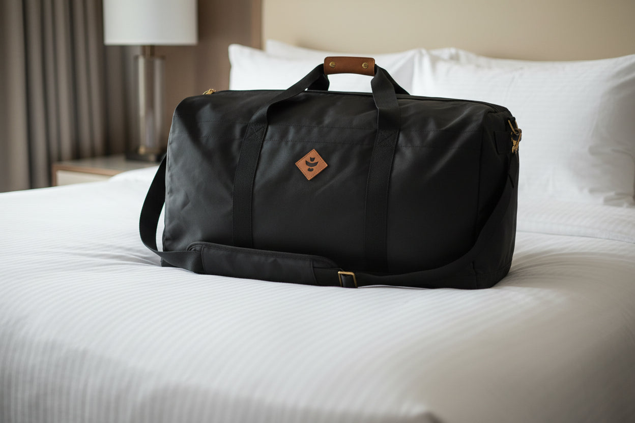 Black duffel bag with brown handles on a white background