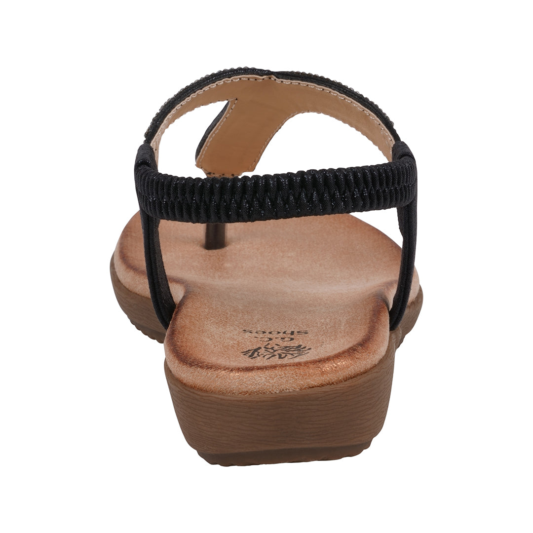 Black sandal with a brown sole on a white background