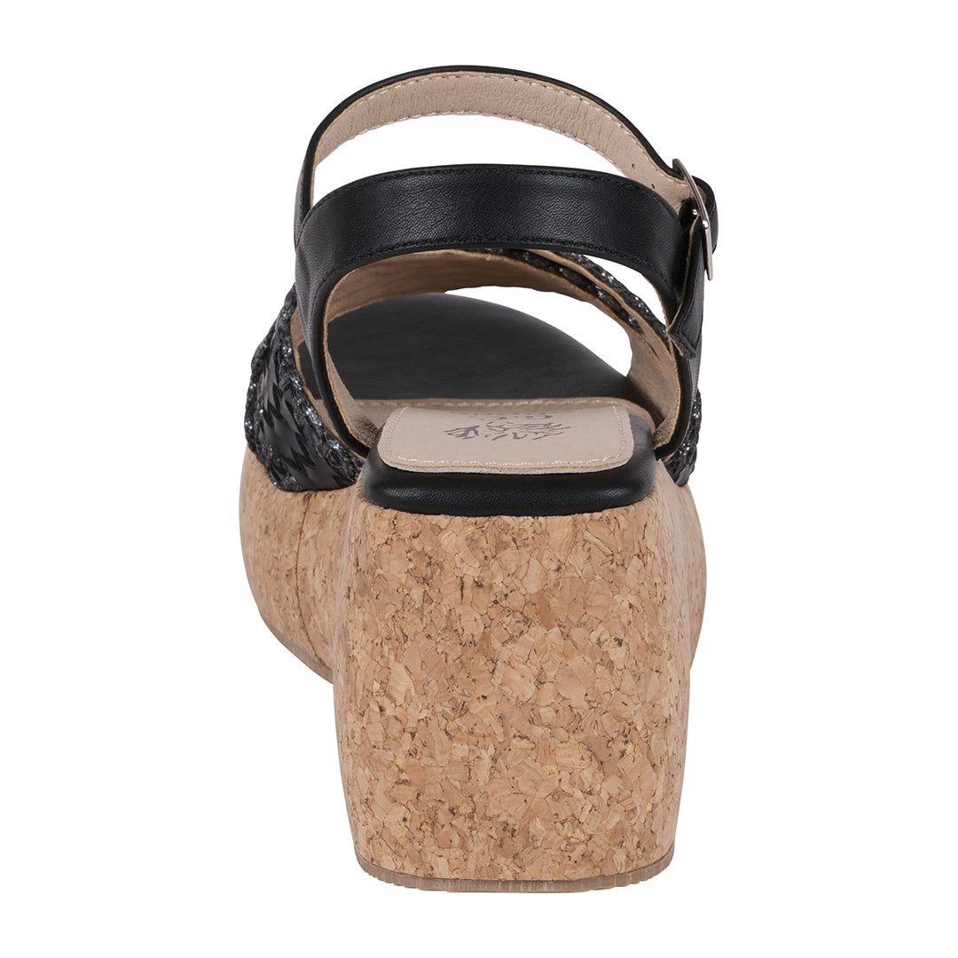Black sandal with cork wedge sole on a white background