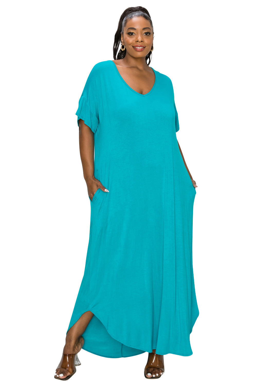 A woman modeling a flowing turquoise maxi dress with short flutter sleeves, a V-neckline, and side pockets, set against a plain white background.