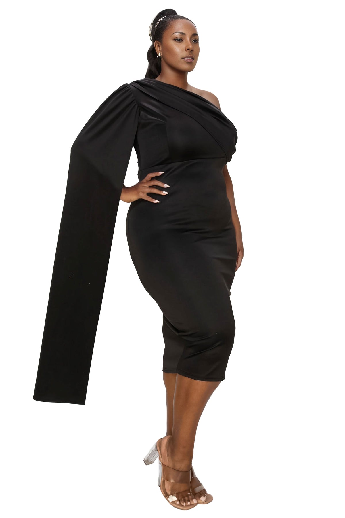 A woman modeling a black one-shoulder midi dress with a dramatic draped capelet sleeve, photographed against a solid white background.