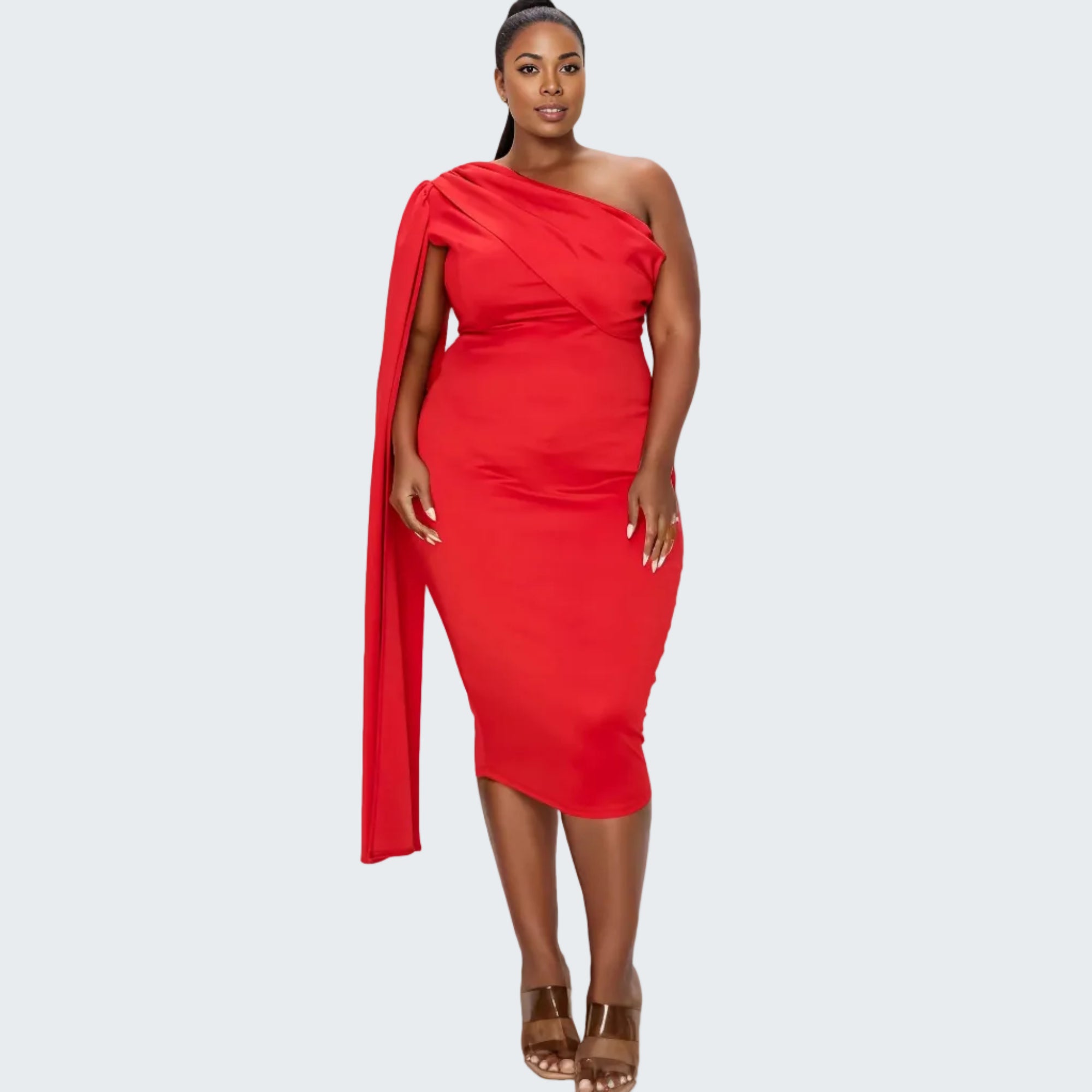 A woman modeling a bright red one-shoulder midi dress with a draped neckline and matching draped fabric at the shoulder, paired with brown strappy sandals against a plain white background.