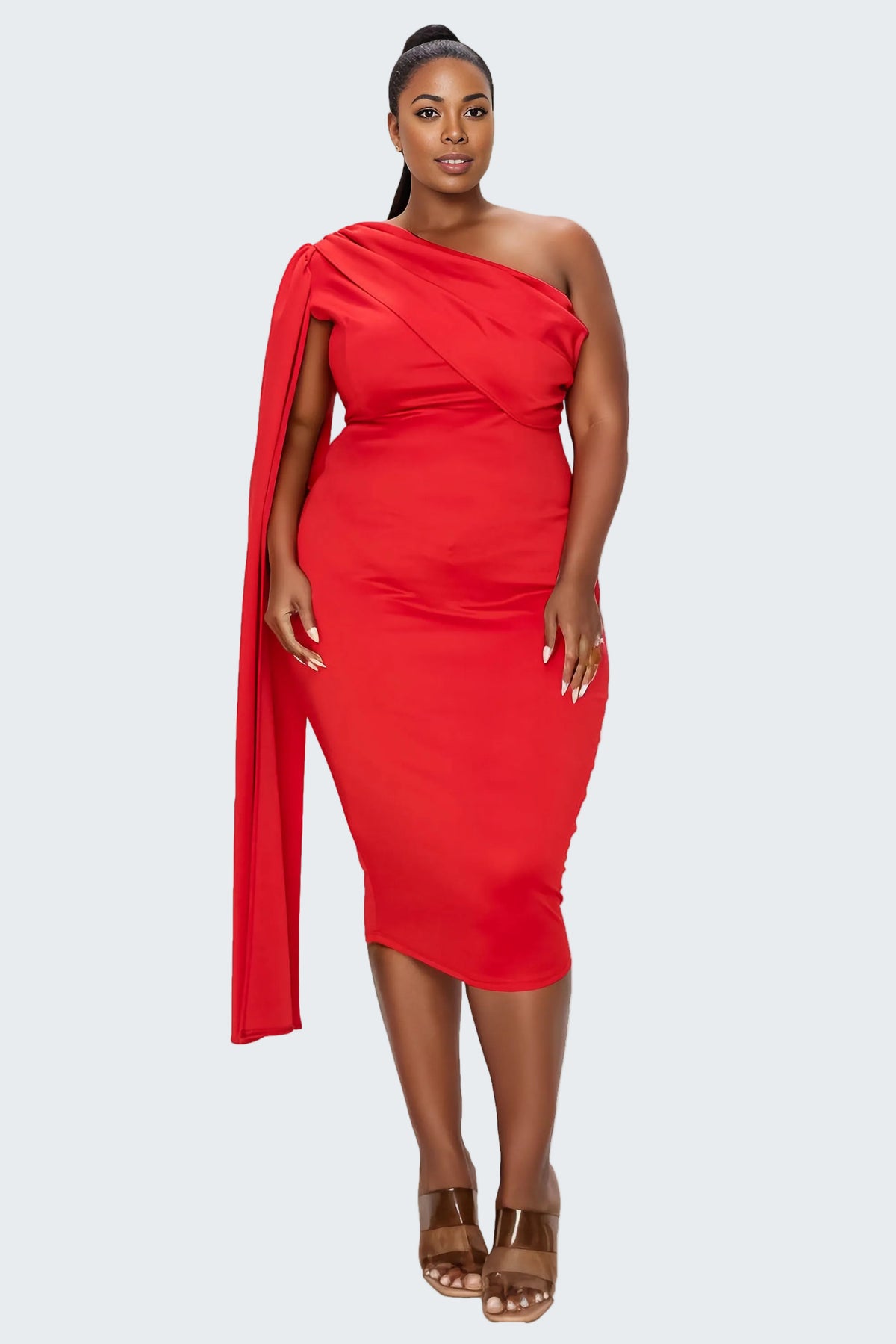 A woman modeling a bright red one-shoulder midi dress with a draped neckline and matching draped fabric at the shoulder, paired with brown strappy sandals against a plain white background.
