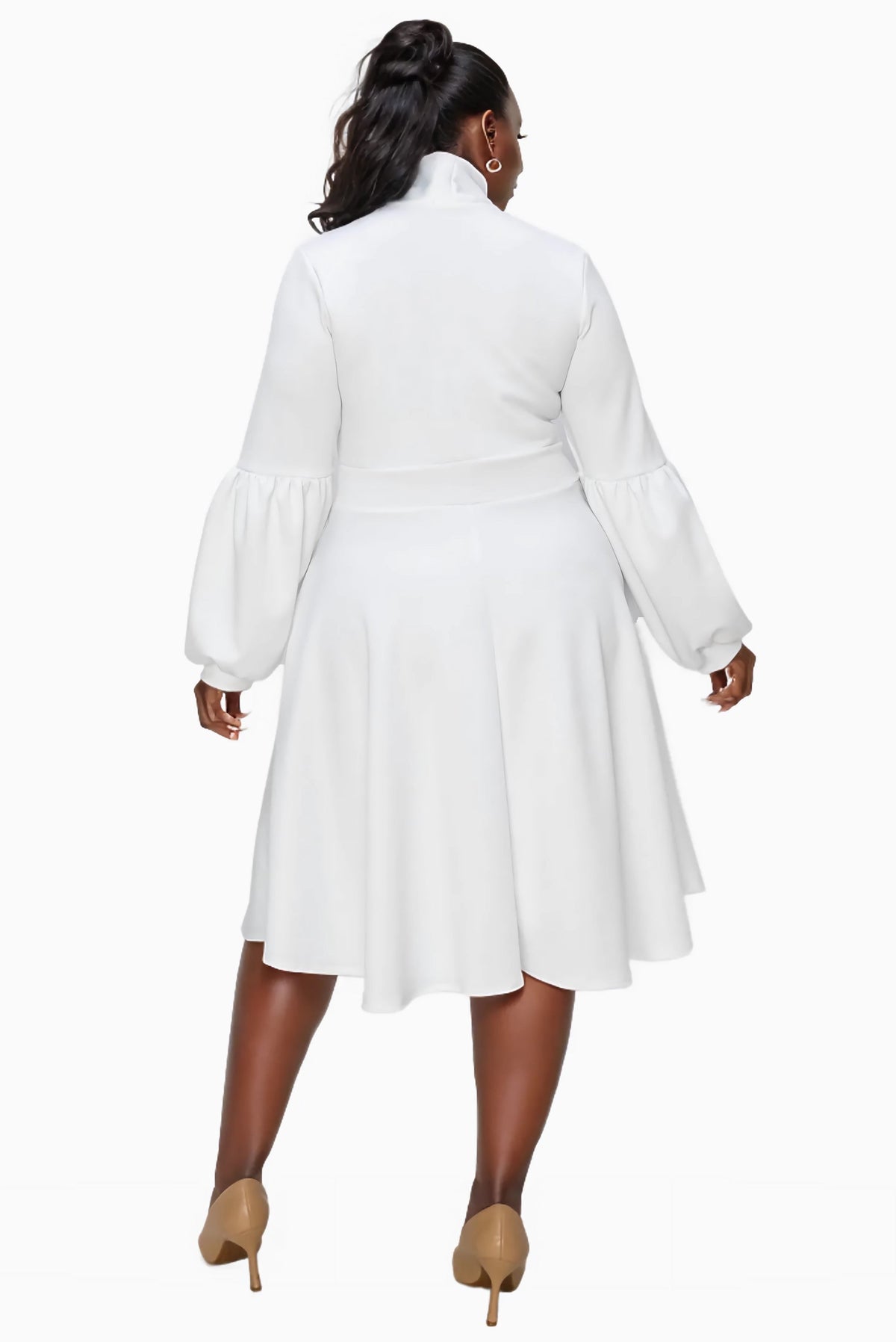 A woman shown from the back wearing a white long-sleeve midi dress with a high mock neck and flared skirt, paired with beige heels, against a plain white background.