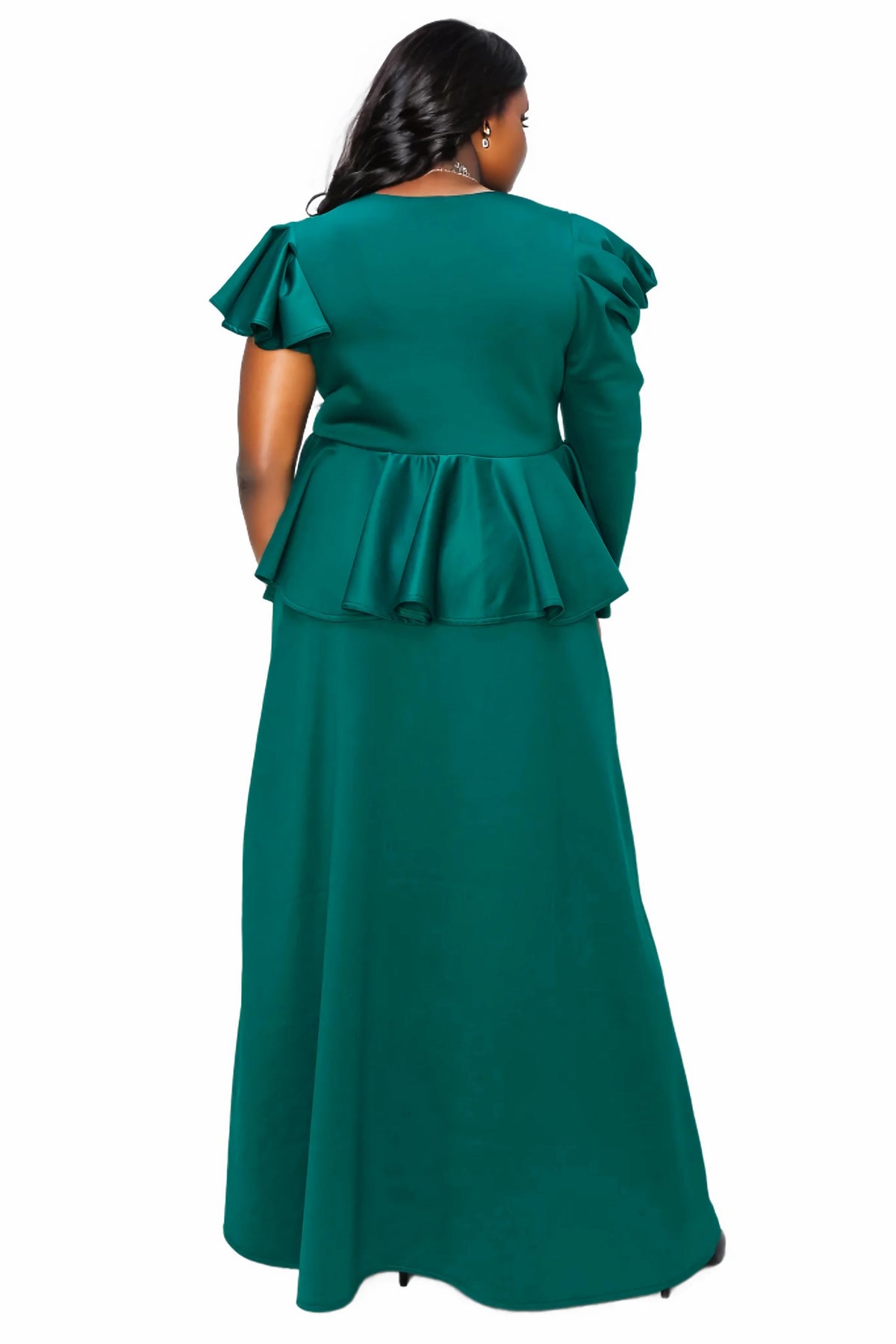 A woman viewed from the back wearing a long emerald green dress with ruffled short sleeves and a ruffled waist detail, set against a plain white background.