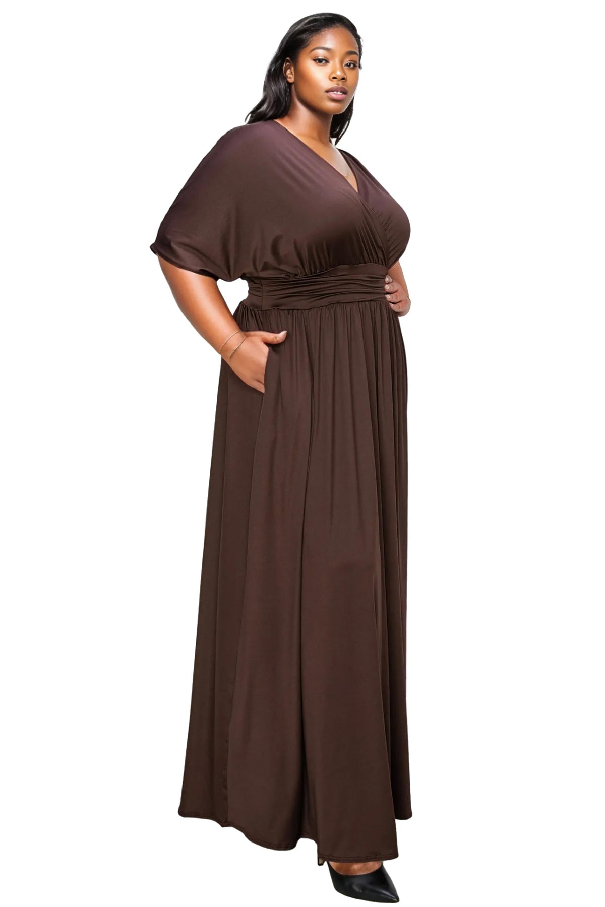 A woman modeling a floor-length brown wrap maxi dress with short flutter sleeves and a gathered waist, shown against a plain white background.