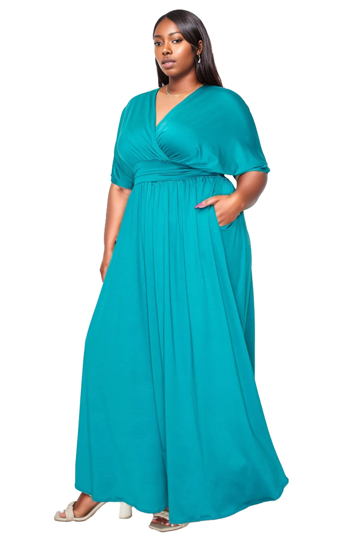 A woman modeling a teal green maxi dress with short flutter sleeves, a V-neckline, and side pockets, set against a plain white background.