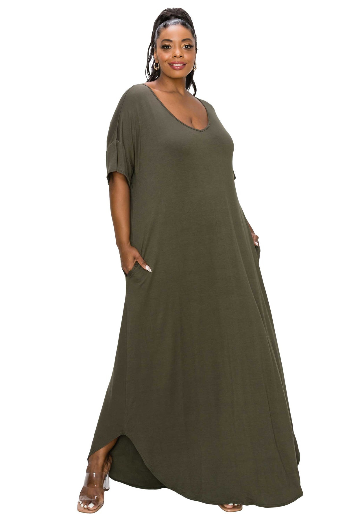 A woman modeling a loose, olive green maxi dress with short sleeves, a deep scoop neckline, and side pockets, set against a plain white background.